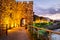 Seaside sunset landscape - fortress wall and tower with illumination