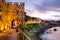 Seaside sunset landscape - fortress wall and tower with illumination