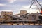 Seaside view of large ship unloading ports - storage warehouses. Photo taken on cloudy sunset.