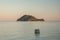 Seaside view of the Marathonisi or Turtle island near Greek island Zakynthos in the Ionian Sea wuht a boat in front of