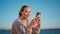 Seaside woman looking smartphone in sunset sunlight closeup. Happy travel girl