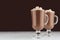 Season hot chocolate milk cocktail with marshmallows, cocoa powder in elegant dark brown bar interior, copy space.