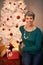 The season that makes everybody smile. Portrait of a happy mature woman sitting beside a white Christmas tree.