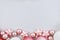 Seasonal Christmas background with white and pink tree baubles in shape of balls and stars at bottom and empty copy space