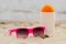 Seasonal concept, shells, pink sunglasses and sun lotion