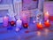 Seasonal festive interior composition of balls, lit candles, wooden frames, decorative lamps, felt hearts, paper for notes on a wo