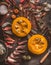 Seasonal food: Half Hokkaido pumpkin with seeds, knife and fall leaves on dark kitchen table. Autumn mood. Top view