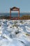 Seasonal frost covered framed red bench sea view