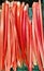 Seasonal local vegetable: Closeup of isolated fresh raw red whole rhubarb stalks in a box at german farmers market in may