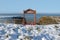 Seasonal snow covered framed red bench sea view