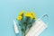 Seasonal spring summer allergy flowers concept. White spray container,Yellow flowers with medical protective mask on blue