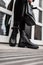 Seasonal trendy collection of women`s boots. Stylish young woman in fashionable spring-autumn black leather shoes in jeans with