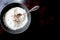 Seasoned flour in a gray bowl with antique silver spoon, left of center, from above