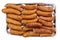 The seasoned and incised sausage lying on an aluminum tray, isolated on a white background with a clipping path.