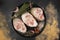 Seasoned pork knuckles on a round plate on a meat table, top view of raw pork knuckles