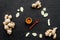 Seasoning. Ground ginger in small bowl near sliced ginger root on black background top view