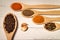 Seasonings for cooking pilaf in wooden spoons on the table.
