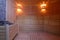 Seat in sauna room. Empty wooden steam room with stone heater.