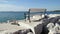 Seat at sea. White bench on rocks on beach of sea. Beautiful view of bench white rocks and stones with blue Adriatic sea.