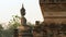 Seated Buddha image facing brick wall of temple