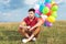 Seated casual man with balloons looks away