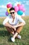 Seated casual man with balloons and sunglasses