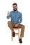 Seated hipster showing ok sign with thumb up