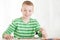 Seated smiling boy holds brush in hand