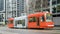 Seattle streetcar in downtown painted orange with pantograph raised