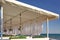 Seaview Restaurant Exterior. White Terrace With Wooden Furniture