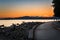 Seawall and a Bay with Mountains on Horizon at Sunset