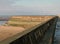 Seawall in blackpool with the beach at low tide in sunlight with the wall of the old boat pool