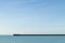 Seawall and lighthouse with blue sky at Newhaven Harbour