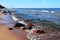 Seawater and waves flooding colored stones on the beach.