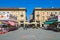 Sebaste stalls on Piazza Ferrero under blue sky in Alba, Italy.