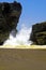 Secluded black lava sand beach cove, powerful heavy violent surf waves breaking between rocks, misty sea spray foam  - Cobquecura