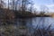 Secluded icy pond in a winter wonderland, surrounded by snow-covered grass and glistening water