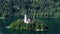 Secluded island with church surrounded by Lake Bled and Alps, spirituality