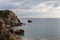 Secluded Mediterranean bay with rocks and cloudy sky