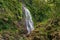 Secluded tropical waterfall in rainforest nature background