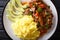 Seco de chivoï¿½is goat stew with yellow rice and avocado close-up