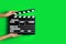 Second assistant camera holding clapper board against chroma key background, closeup. Space for text