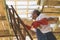 Second floor constuction.Carpenter holding wooden beam and climbing up the ladder