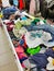 In the second-hand store, there are baskets with a variety of clothes in bulk for different tastes