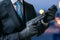 Secret agent holds pistol with silencer in hands at twilight