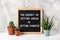 The Secret Of Getting Ahead Is Getting Started. Motivational quote on letter board, cactus, succulent flower on white table.