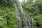 Secret jungle waterfall cascade in tropical rainforest with rock