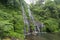 Secret jungle waterfall cascade in tropical rainforest with rock