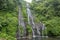 Secret jungle waterfall cascade in tropical rainforest with rock