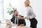 Secretary giving coffee to smiling colleague